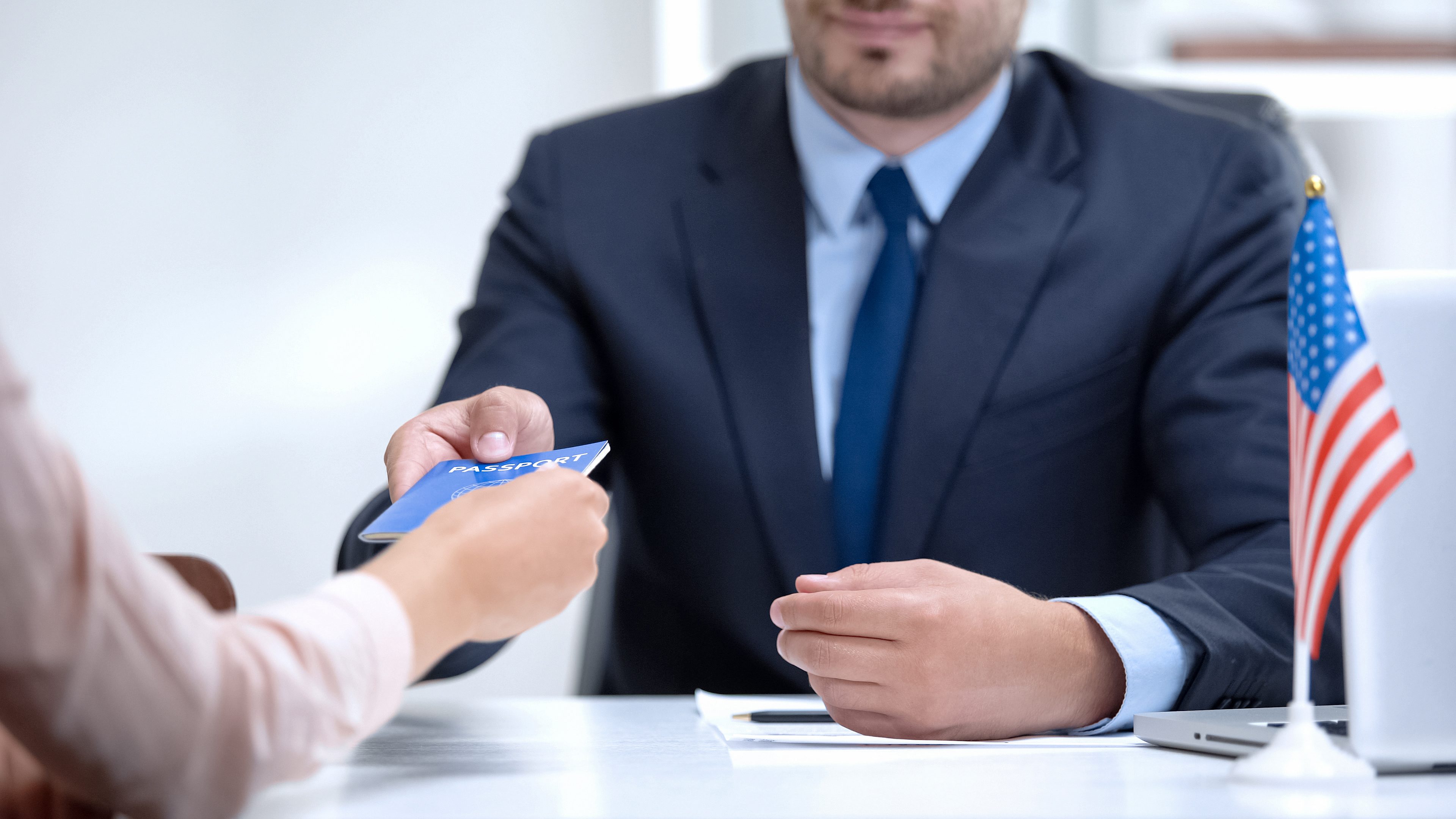 American consular officer giving passport to female immigrant, refugee visa American consular officer giving passport to female immigrant, refugee visa