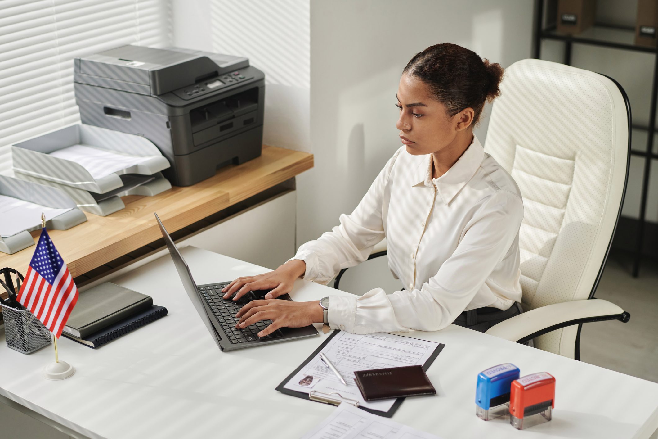Businesswoman typing on laptop in office Businesswoman sitting at her workplace and typing data of documents in laptop