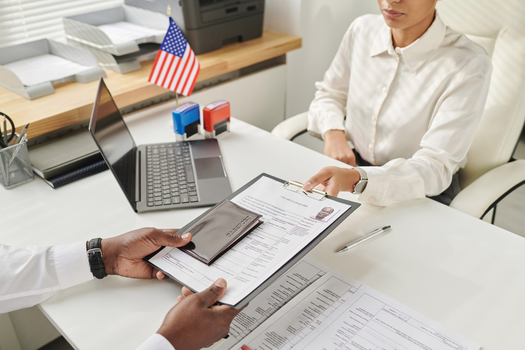 Specialist taking document to make visa Young specialist taking document from man to make visa in visa center