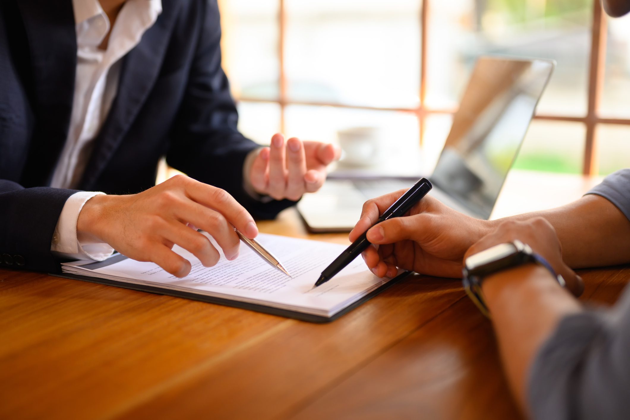 Closeup lawyer or insurance agent pointing at contract showing male client where to signature sign Closeup lawyer or insurance agent pointing at contract showing male client where to signature sign.